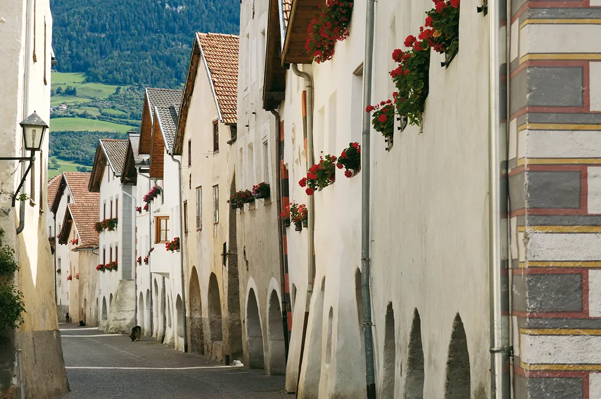 Altstadt-Gasse mit historischen Häusern und Laubenbögen in der mittelalterlichen Stadt Glurns im Vinschgau.